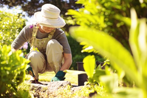 Gardener working in a Chessington garden showing tidy lawn